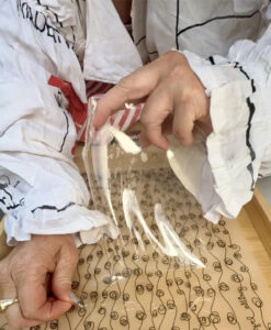 A close-up of Juniper's hands carefully shaping translucent bioplastic, capturing the intricate details and texture of the material. The bioplastic glows softly under the natural light, hinting at its role in my upcoming series, "The Pearl Within"